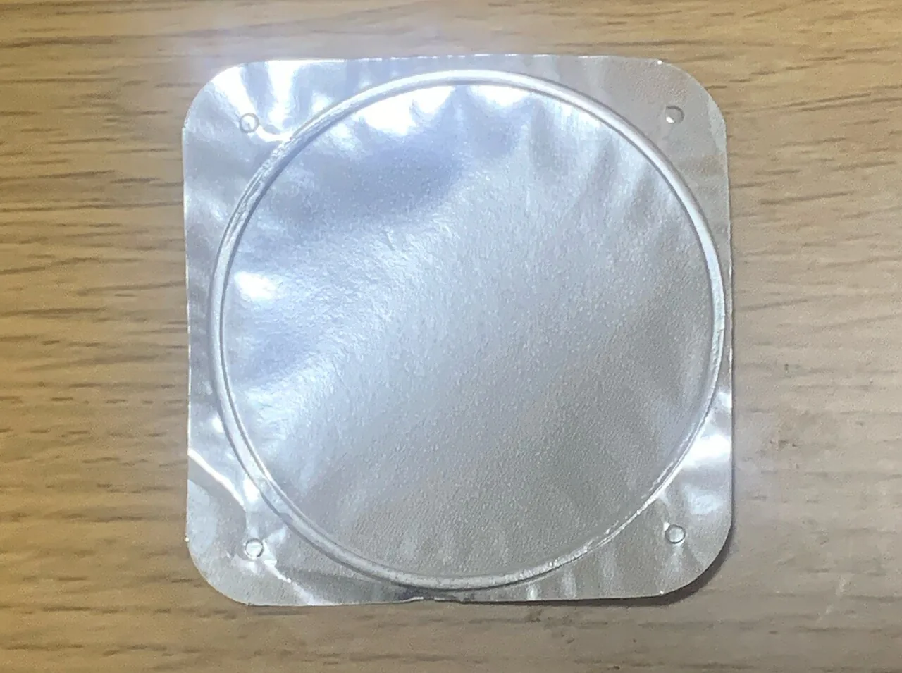 Opened yogurt container with a peelable foil lid and clean rim