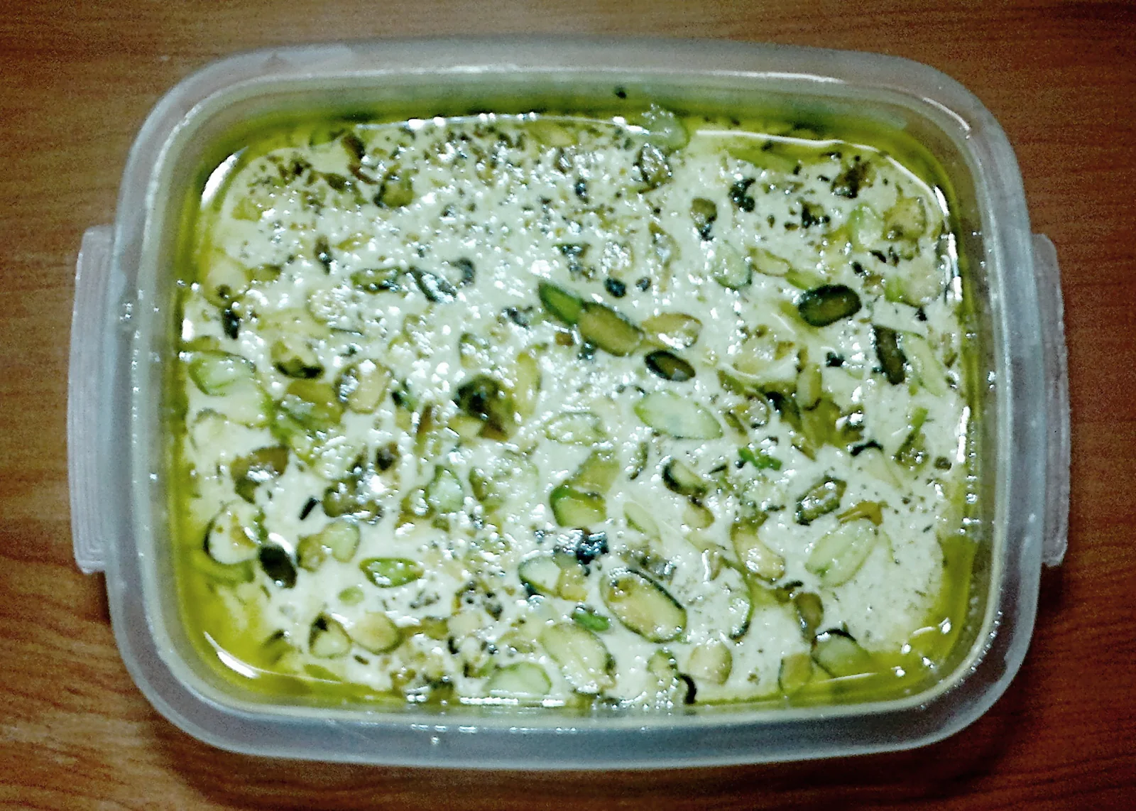 Real open rectangular plastic food tub containing halva, viewed from above with its rim and side tabs visible