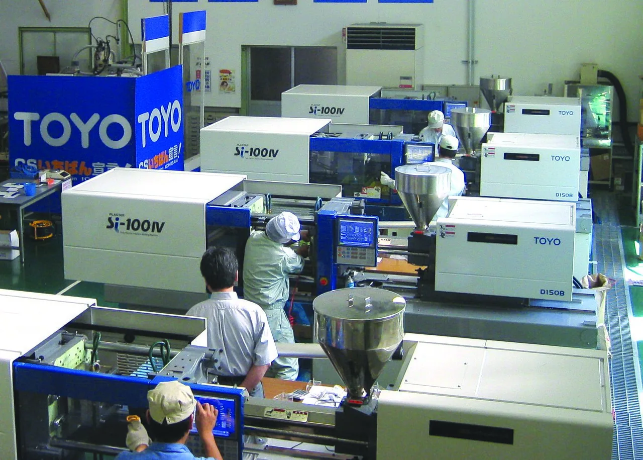 Operators working around injection molding equipment in a third-party workshop